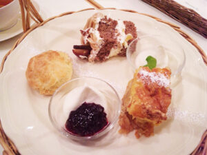 チョコレートケーキやスコーン、ホイップなどが乗ったお皿。