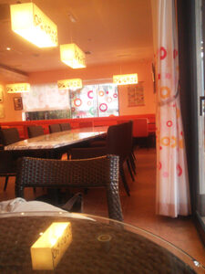 照明でオレンジ色に染まった店内とオレンジ色のソファ席。