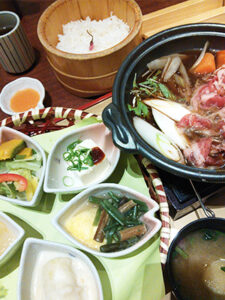 桜の花びらの形の器に入ったお惣菜たちと牛すき鍋。