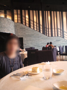 テーブルに着く母と壁に沿った緩やかな階段。