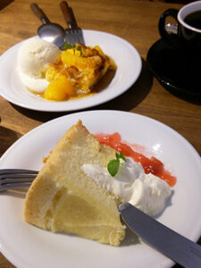 ホイップクリームの乗ったシフォンケーキとオレンジのプディング。